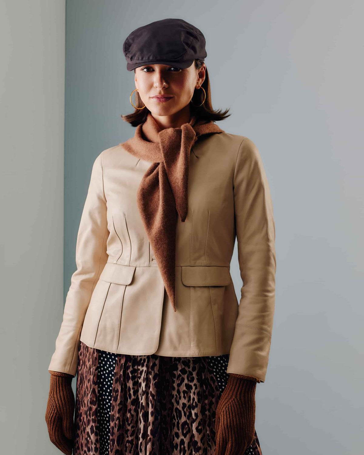 A pair of brown unisex ribbed knit wool gloves. And a unisex brown triangle scarf crafted from pure cashmere. A versatile design that can be tied and styled in multiple ways.