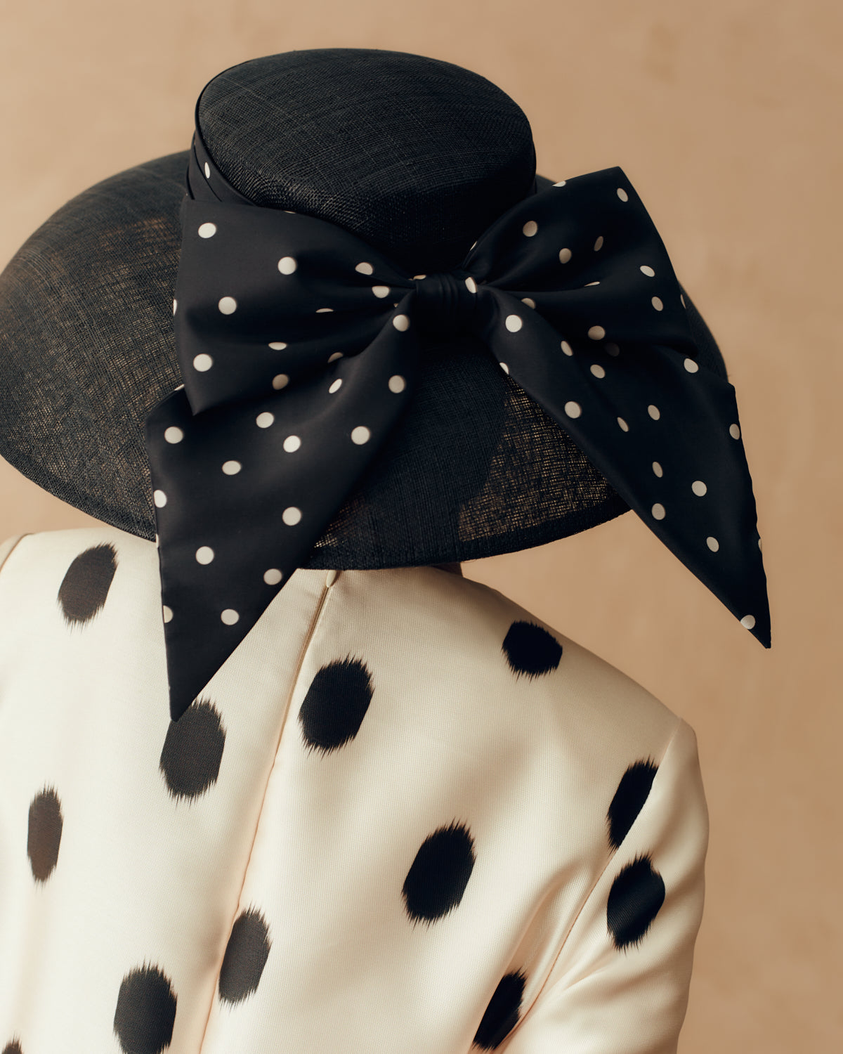 Black sinamay drop brim hat with a silk taffeta polka dot puggery trimband and bow at the back - Lock & Co. Hatters London UK
            