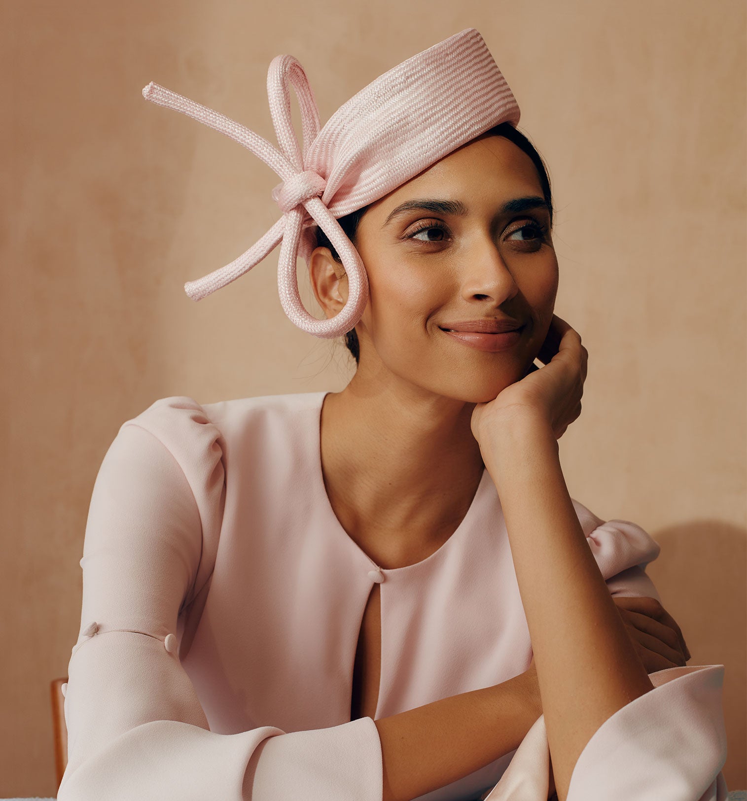 Parasisal straw pink pillbox hat with a bow trim