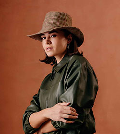 Women's wool wide brim bucket hat with a brown, tan and purple houndstooth pattern.