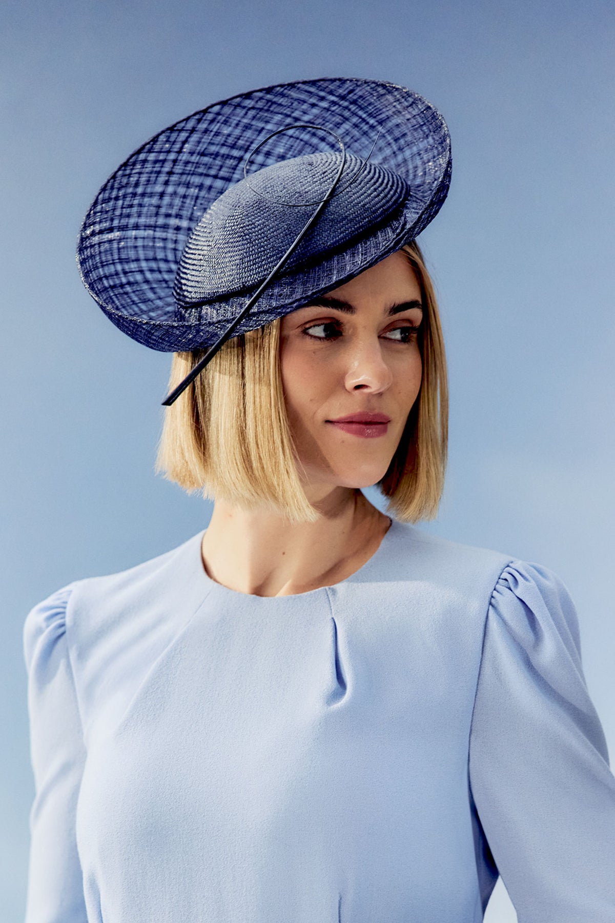 Women's navy parasisal and mesh sinamay percher hat finished with a hand-curled striped ostrich quill.