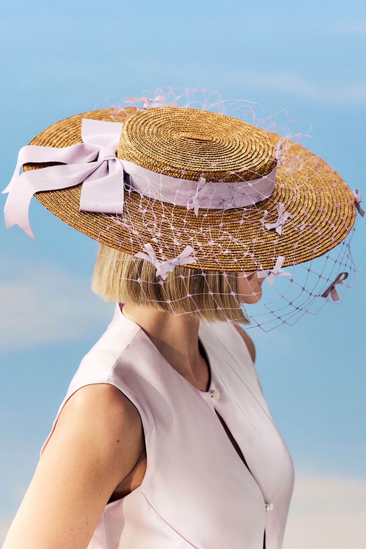 Golden pedal straw boater hat with a lilac cotton petersham ribbon and lilac veiling adorned with miniature bows.