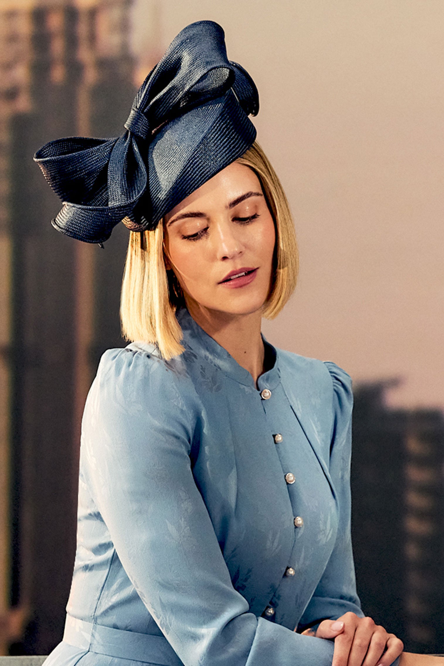 Women's navy parasisal straw pillbox hat with a hand sculpted bow.